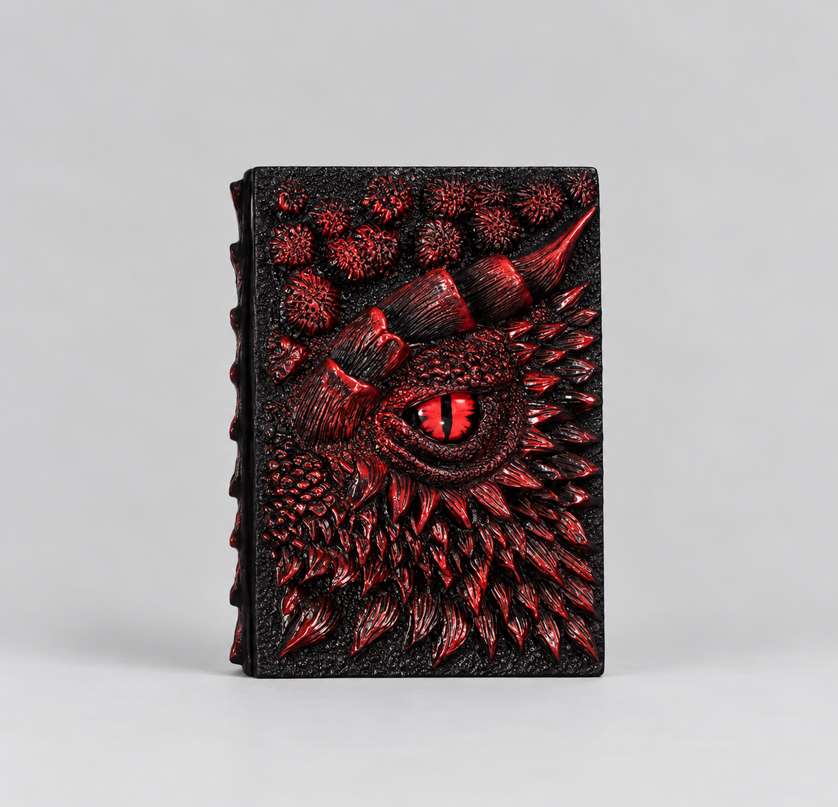 Red embossed dragon notebook standing upright, DnD journal with a dragon eye cover