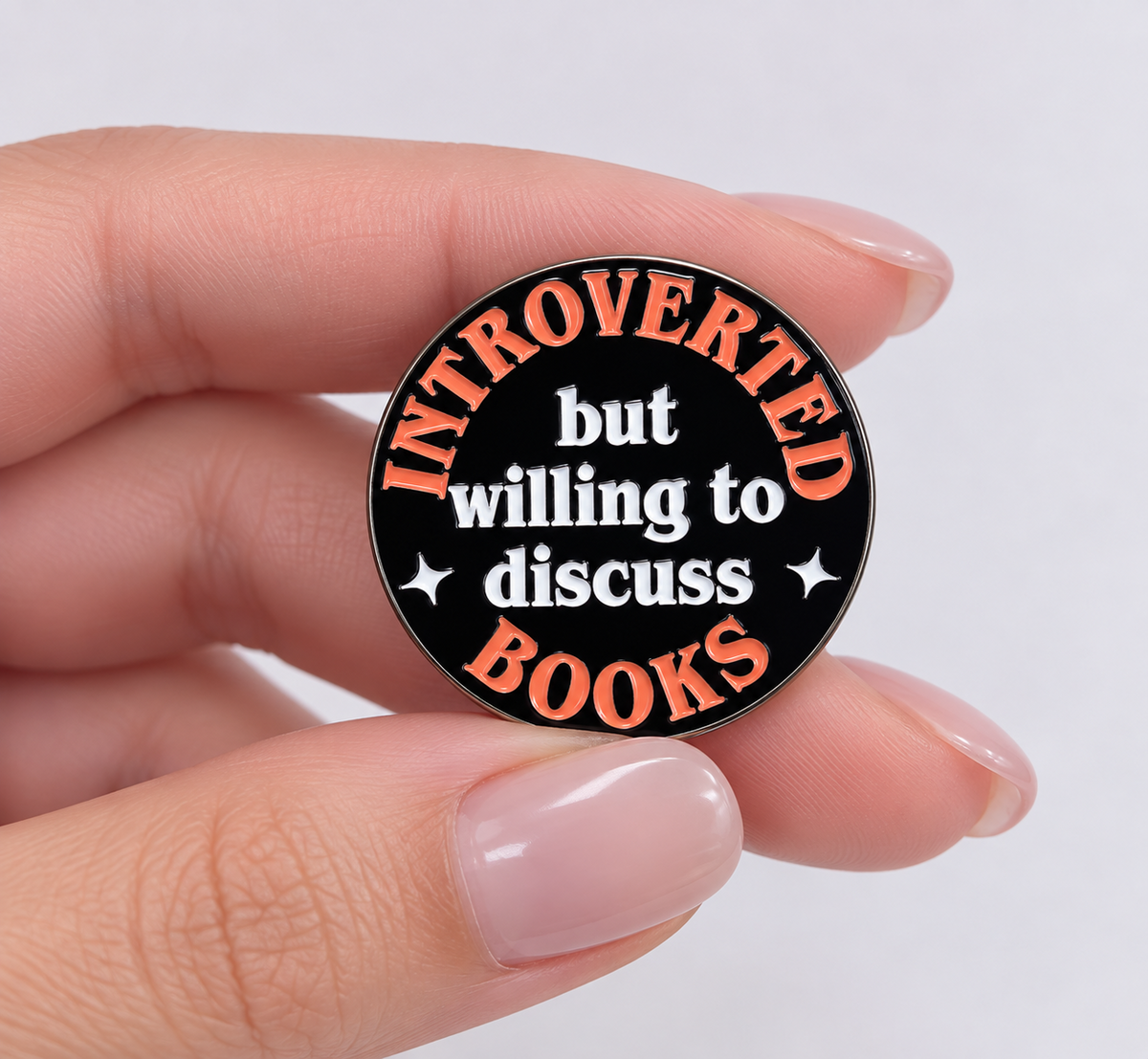Close-up of Introverted But Willing to Discuss Books bookish pin in hand