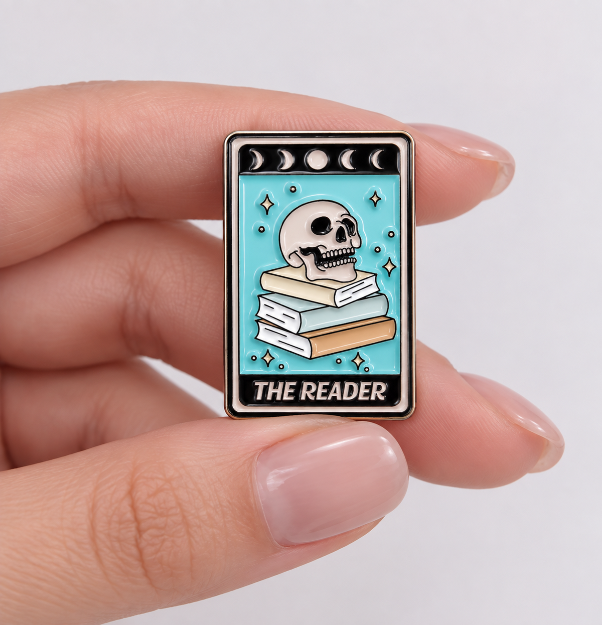 The Reader tarot card enamel pin held in hand to show its size